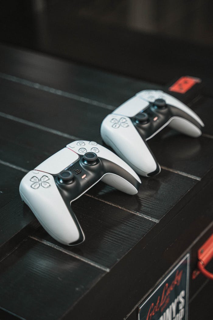 Two white gaming controllers on a black table, perfect for tech or gaming content.