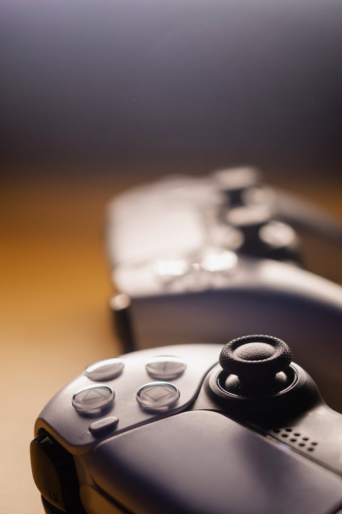 Focused view of sleek game controllers with warm lighting. Ideal for gaming concepts.